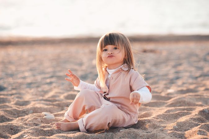 Girl playing with sand at beach