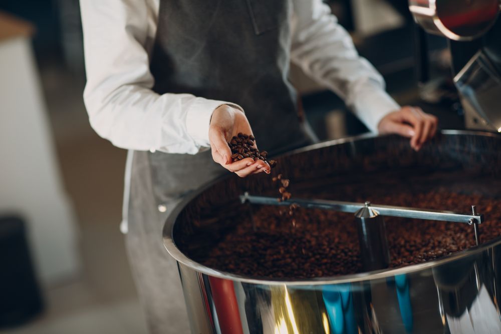 Man in apron roasting coffee beans