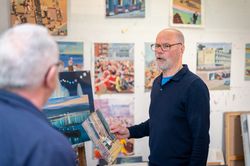 Older male talking to friend in studio