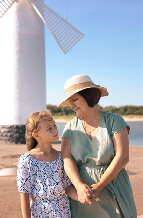 Girl and woman by windmill