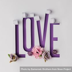 Word LOVE made of torn paper on violet background with flowers 0LaKg5