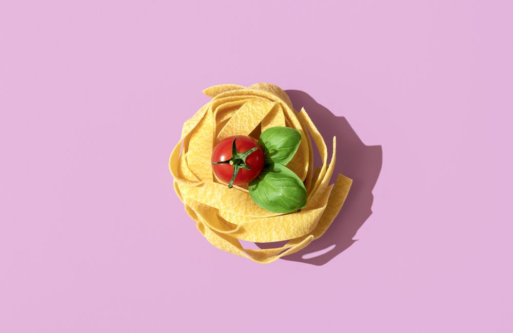 Pasta nest uncooked, top view on a pink background