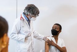Doctor making injection for black woman patient