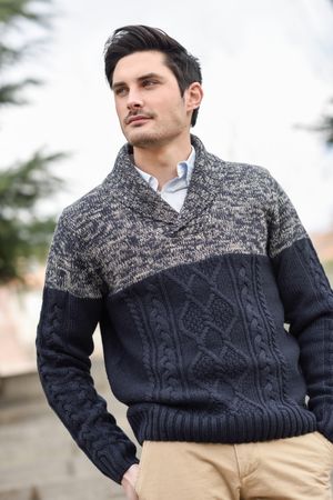Portrait of man in woolen sweater standing outside on overcast day