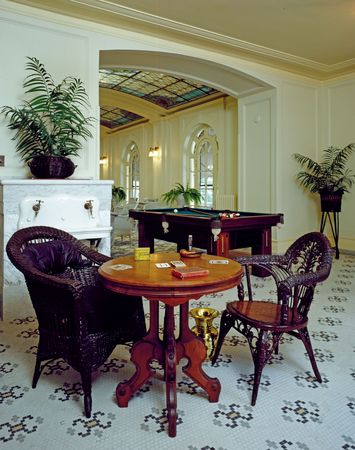 Card table with wicker chairs in airy, tiled room