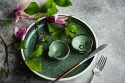 Floral table setting with magnolia branch on grey table