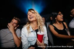 Indoor shot of smiling young woman watching woman in theater 47rPz5