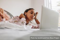Young woman in bed watching movie on laptop 4jr6x4