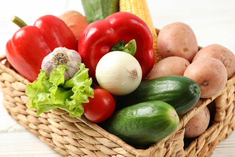 Wicker basket with vegetables on background, close up