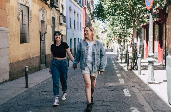 Lesbian couple holding hands walking on street