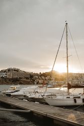 Yachts docked in sea port at sunset