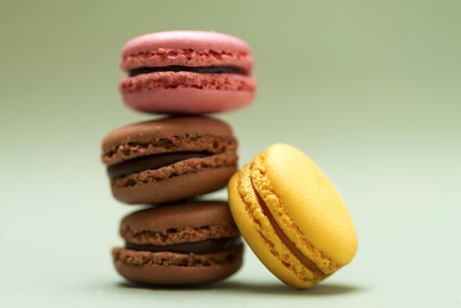 Chocolate, strawberry & lemon macaroons on a green table