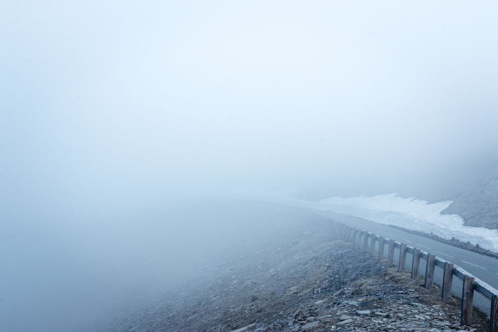 Fog over asphalt mountain road