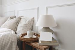 Bedside table with tray of coffee, lamp and blank card