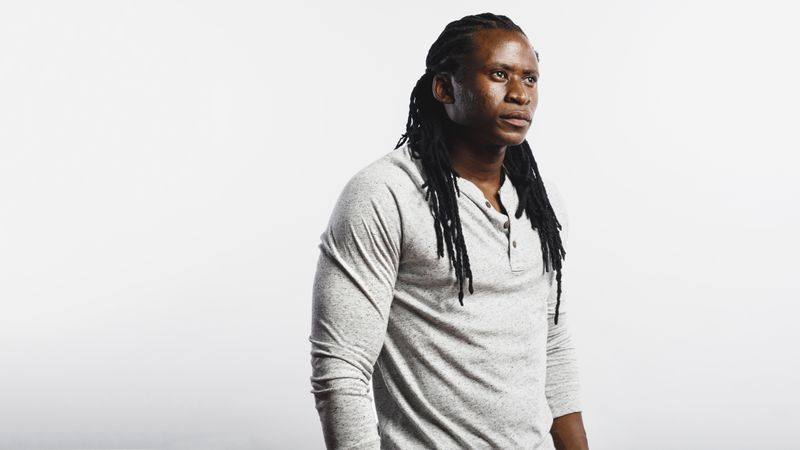 Muscular male with dreadlocks isolated on neutral background