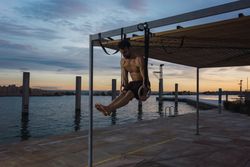 Athletic man balancing on gymnastic rings