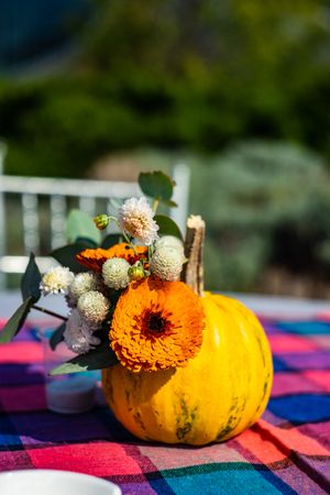 Single squash on table cloth with flowers