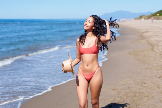 A Joyful Woman Fully Enjoying a Wonderful Day at the Beach with Her Refreshing Coconut Drink