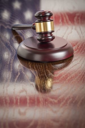 Wooden Gavel Resting on Flag Reflecting Table