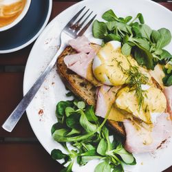 Eggs Benedict with greens, top view, square crop