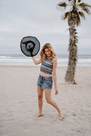 Young female relaxing on beach with hat