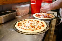 Pizza with tomato and cheese before going into the oven