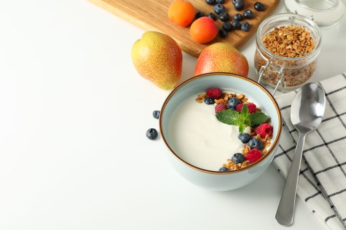 Composition with yogurt dessert and ingredients on blank background, space for text