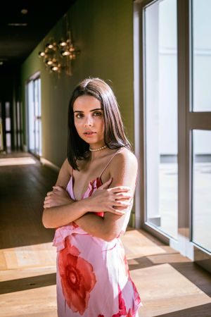 Stylish young woman in dress posing in room