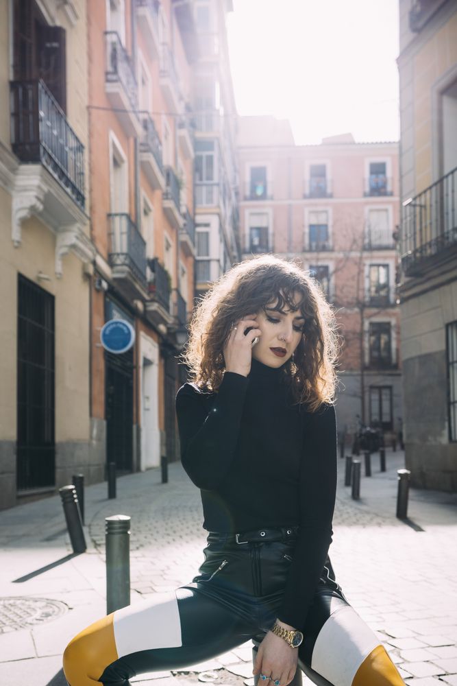 Young woman talking by phone in the street