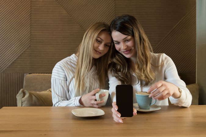 Young women taking selfie in cafe