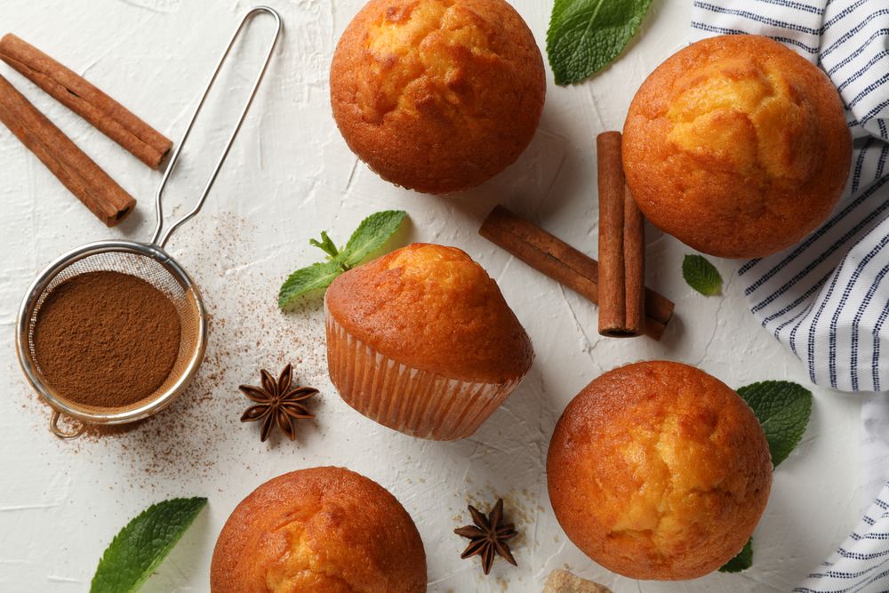 Composition with muffins and cinnamon on light background