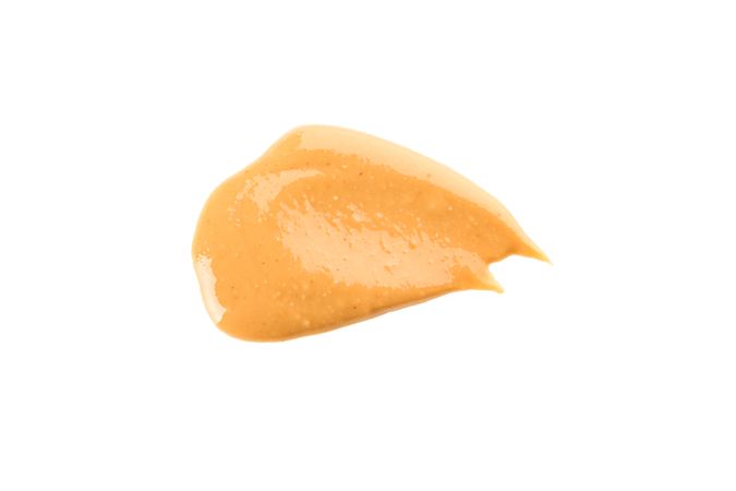 Creamy peanut butter isolated on light background, top view. A traditional product of American cuisine