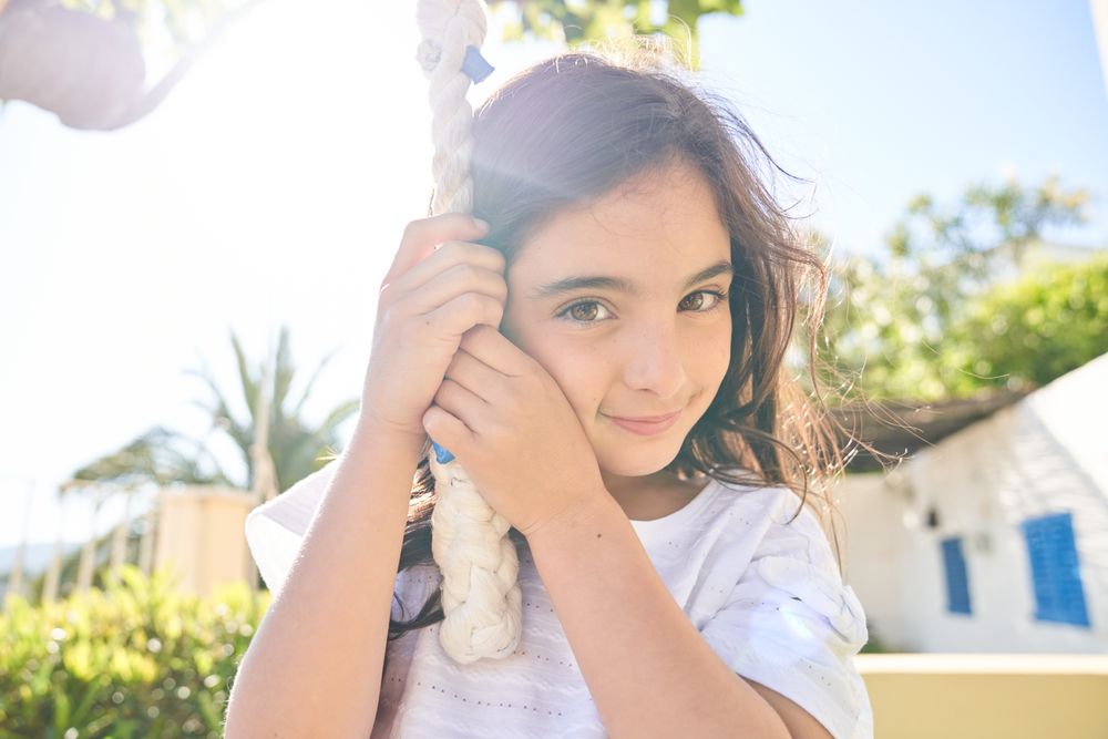 Smiling child holding rope and looking at camera