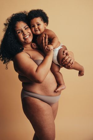 Real body of a healthy mother holding her infant