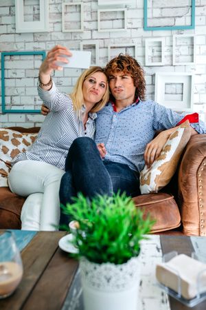 Couple taking selfie on a sofa