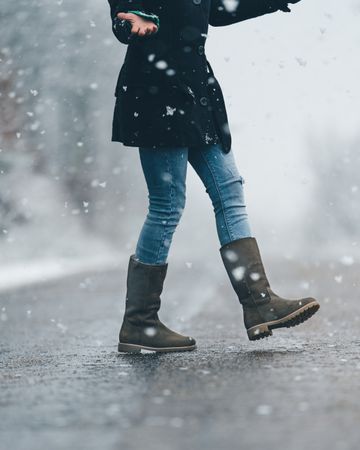 Young woman crossing winter country road