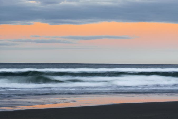 Idyllic seashore with rough waves in sunset