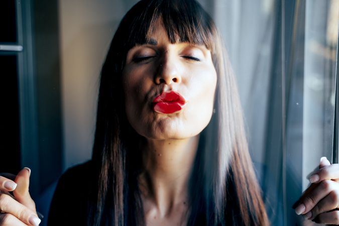 Stylish woman kissing glass