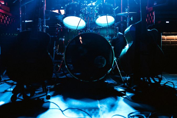 Drum set on stage in blue neon spotlights