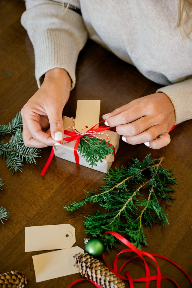 Woman making beautiful Christmas gift at table
