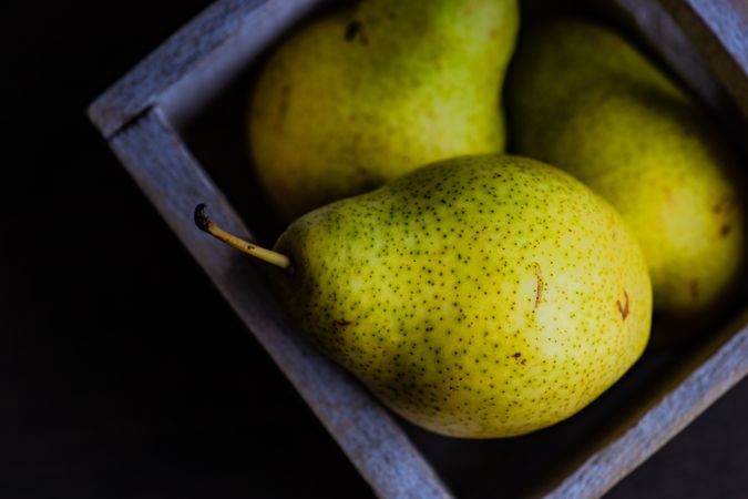 Green organic ripe pear fruits in box