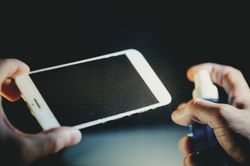 Crop hands cleaning smartphone display