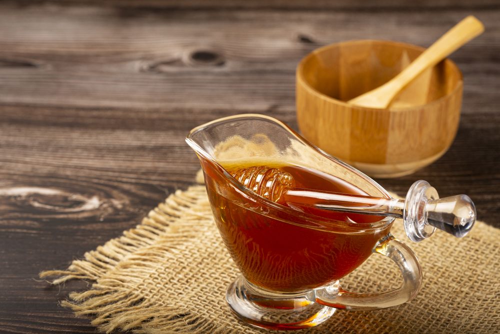 Honey in glass bowl on the table.