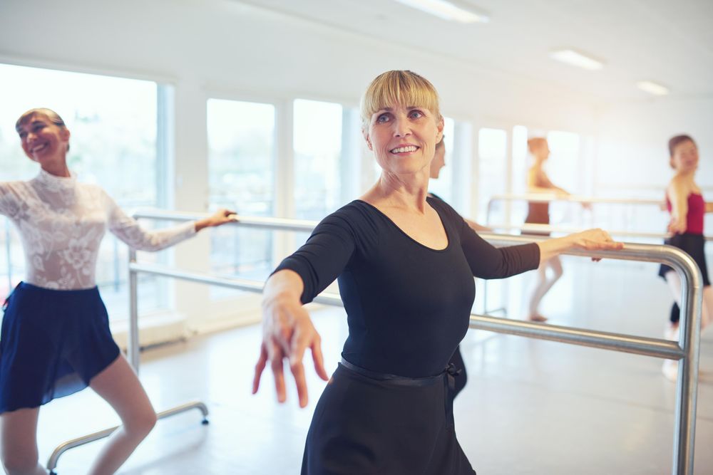 Mature woman doing barre workout in dance studio