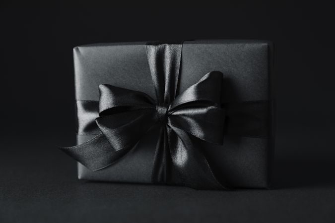 Gift box with dark bow on dark background