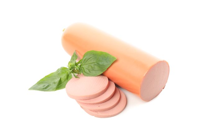 Large sausage in blank room with garnish