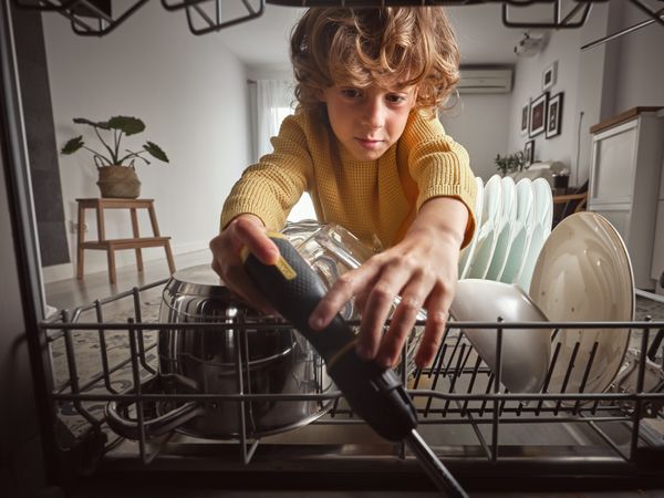 Boy trying to fix dishwasher