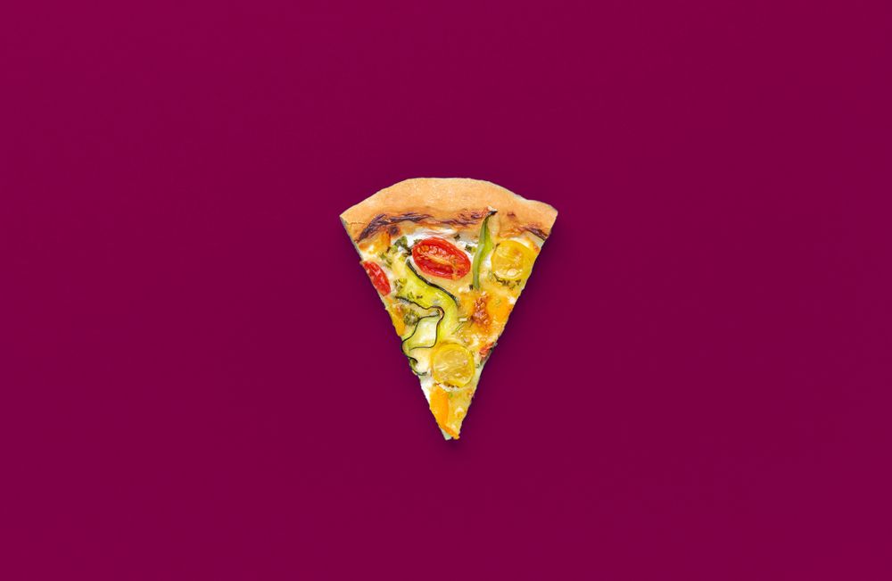 Vegetarian pizza slice isolated on a magenta background