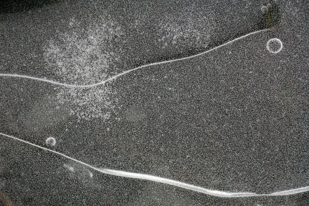 Fragment of thin ice on dark frozen river