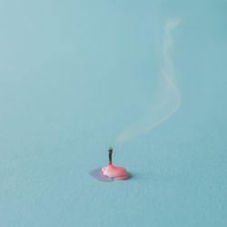 Burnt out pink candle on blue background